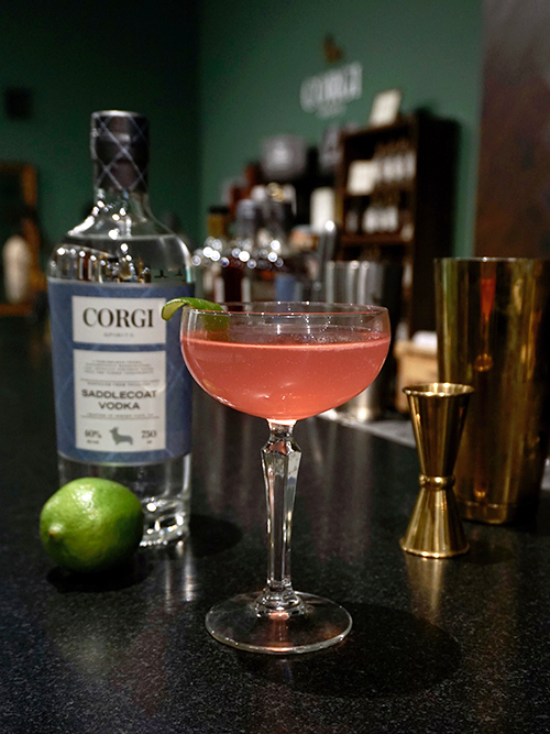 COSMO 2 oz Corgi Spirits Saddlecoat Vodka 3/4 oz Triple Sec 3/4 oz fresh lime juice 1 oz cranberry juice cocktail Add all the ingredients into a shaker with ice and shake. Strain into a chilled cocktail glass. Garnish with a lime wedge.
