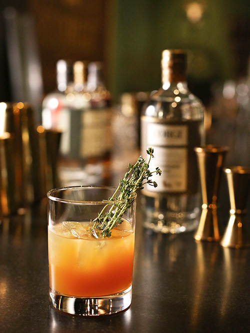 THYME FOR CIDER 1.5 oz Corgi Spirits Pembroke Gin 3 oz fresh apple cider 0.25 oz ginger simple syrup (see below) 3 thyme sprigs Thyme sprig for garnish Fill a shaker with ice add all ingredients and shake vigorously. Strain into a rocks glass over fresh ice and garnish with a thyme sprig. To make ginger syrup, combine 1 cup water with 1 cup sugar and 1 large knob of ginger, finely diced, in a saucepan and bring to a boil. Remove from heat and allow to steep until cool. Strain and reserve syrup.